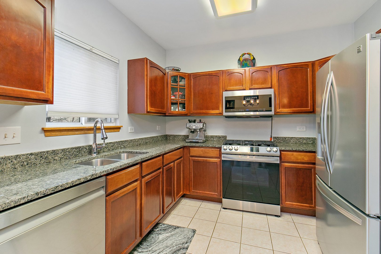 25649 Brooks Farm Road Round Lake, IL 60073 - Photo 8 of 24 a kitchen with stainless steel appliances granite countertop a sink stove and microwave
