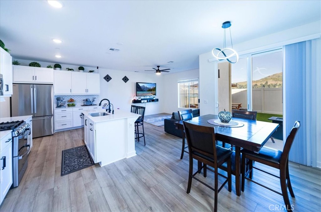 a view of a dining room with furniture a chandelier and wooden floor