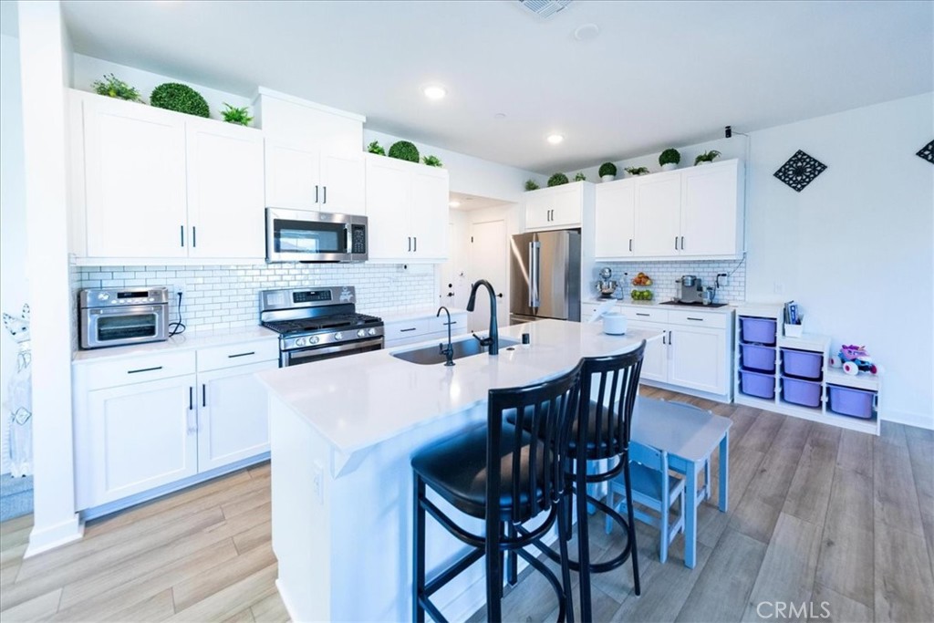 35246 Blossom Place Fallbrook, CA 92028 - Photo 13 of 62 a kitchen with stainless steel appliances a dining table chairs microwave and sink