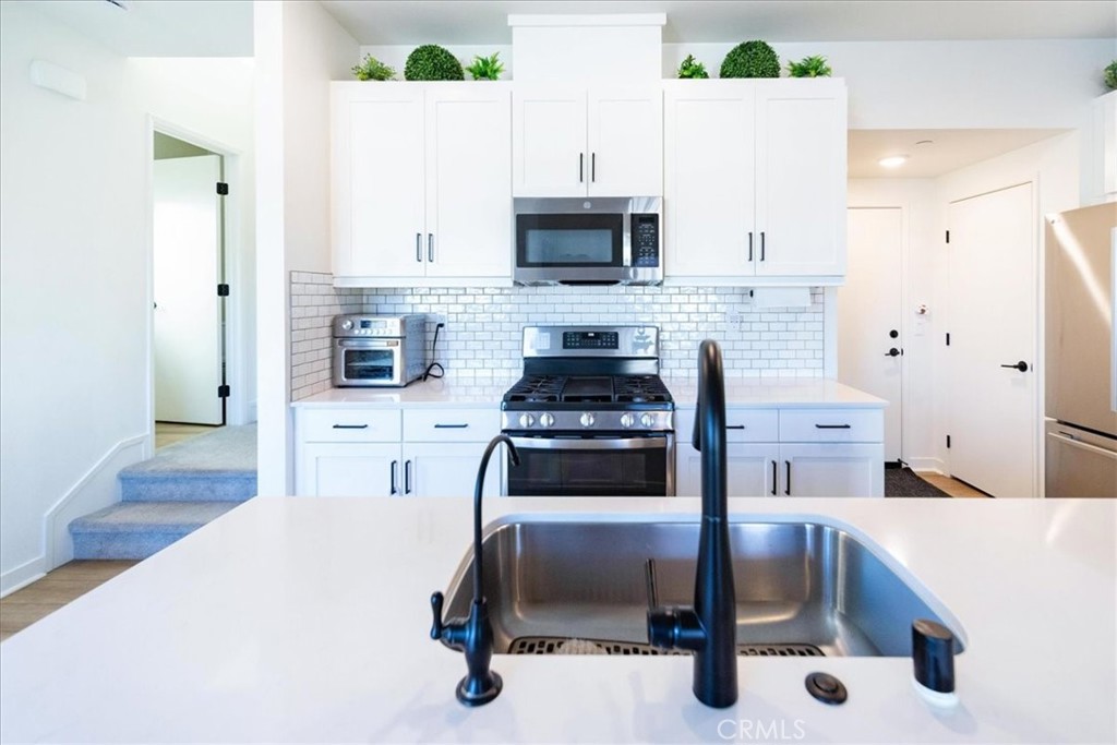 35246 Blossom Place Fallbrook, CA 92028 - Photo 16 of 62 a kitchen with stainless steel appliances a stove a sink and a refrigerator
