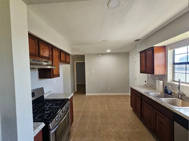 a kitchen with stainless steel appliances a sink and cabinets