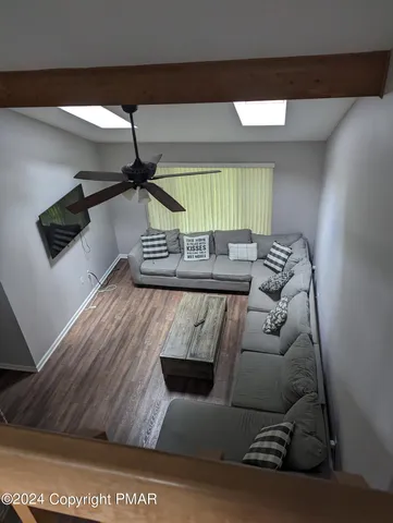 a living room with furniture and a wooden floor