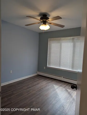 a view of wooden floor and a chandelier fan in a room