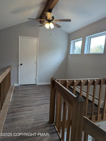 a view of a hallway with wooden floor and staircase