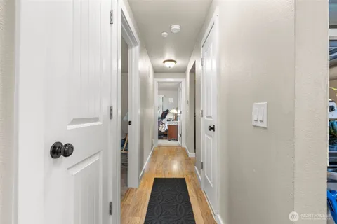 a view of a hallway with wooden floor and a living room