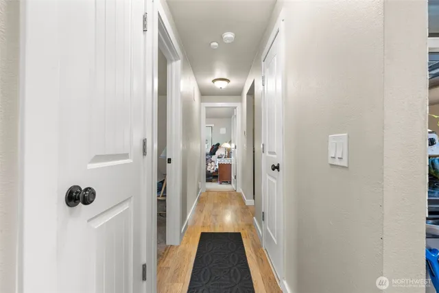 a view of a hallway with wooden floor and a living room