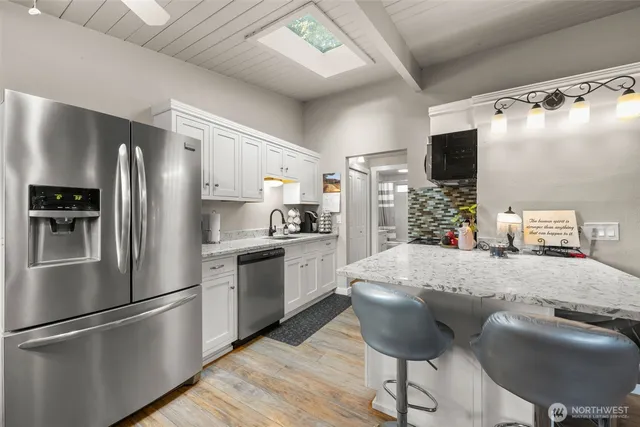 a kitchen with stainless steel appliances granite countertop a refrigerator and a stove top oven