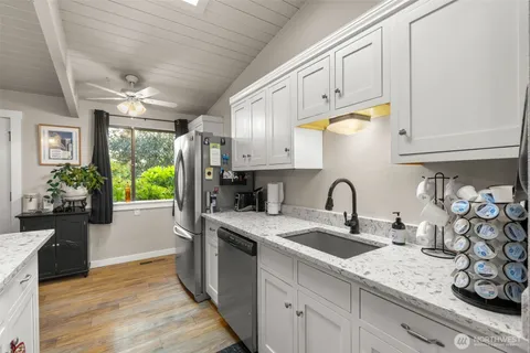 a kitchen with stainless steel appliances granite countertop a sink a stove and cabinets