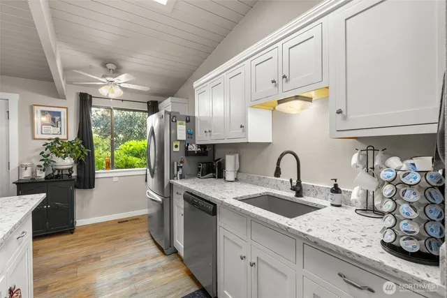 a kitchen with stainless steel appliances granite countertop a sink a stove and cabinets