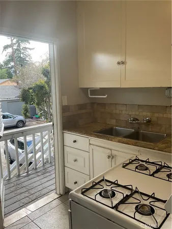 a kitchen with a sink a stove and cabinets