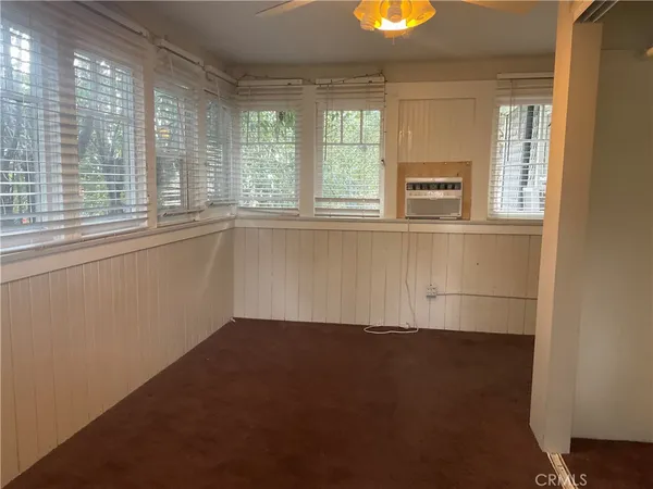 an empty room with windows and sink