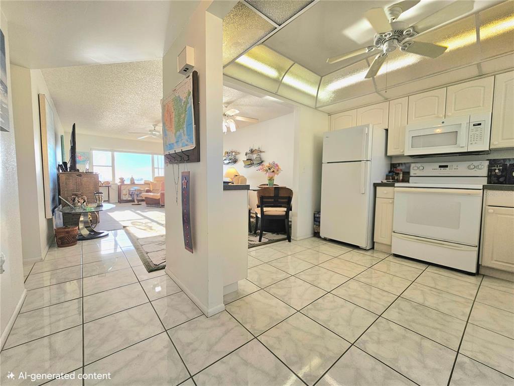 4525 Cove Circle, Unit 1002 St. Petersburg, FL 33708 - Photo 12 of 42 a kitchen with cabinets and chairs