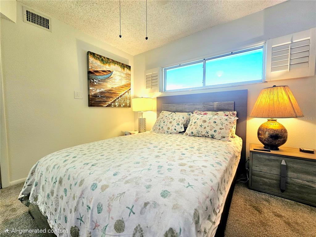 4525 Cove Circle, Unit 1002 St. Petersburg, FL 33708 - Photo 14 of 42 a bedroom with a bed and painting on the wall