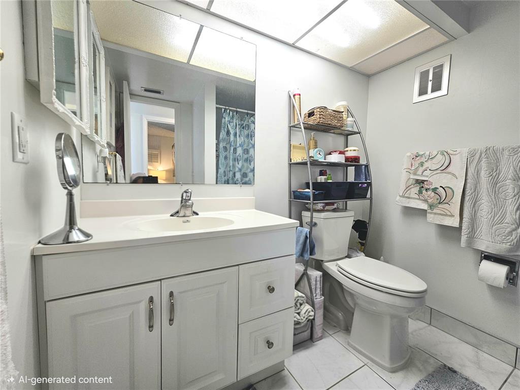 4525 Cove Circle, Unit 1002 St. Petersburg, FL 33708 - Photo 15 of 42 a bathroom with a sink toilet mirror and vanity