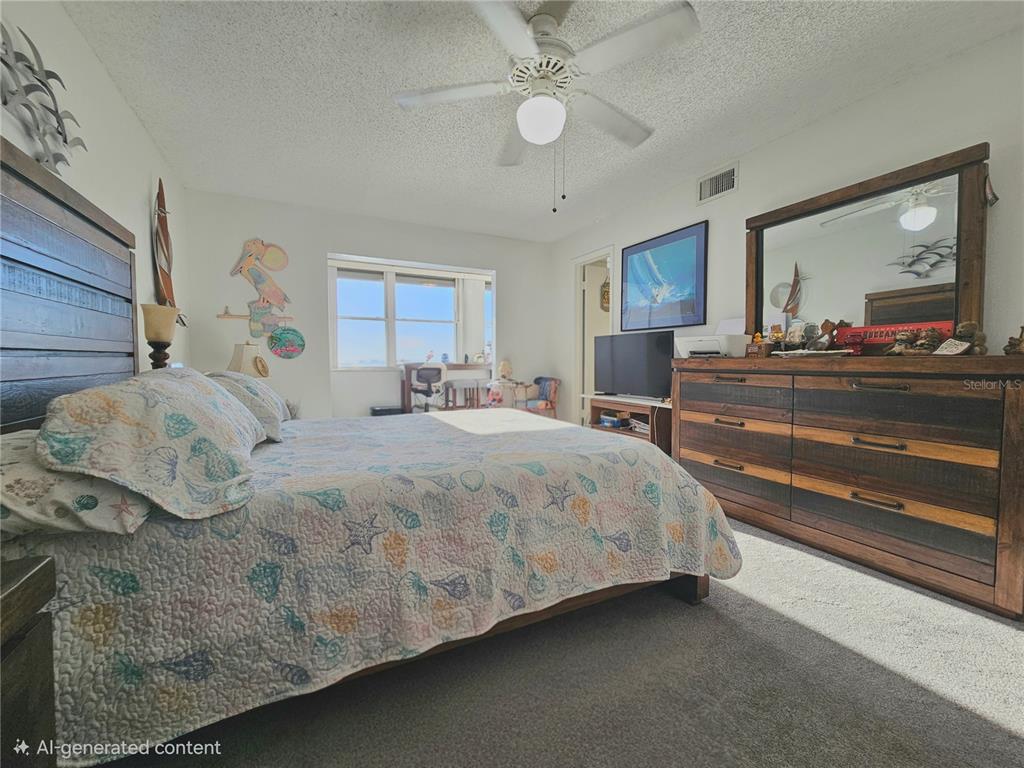 4525 Cove Circle, Unit 1002 St. Petersburg, FL 33708 - Photo 18 of 42 a bedroom with a large bed and a chandelier