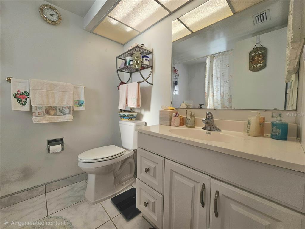 4525 Cove Circle, Unit 1002 St. Petersburg, FL 33708 - Photo 19 of 42 a bathroom with a toilet sink and mirror