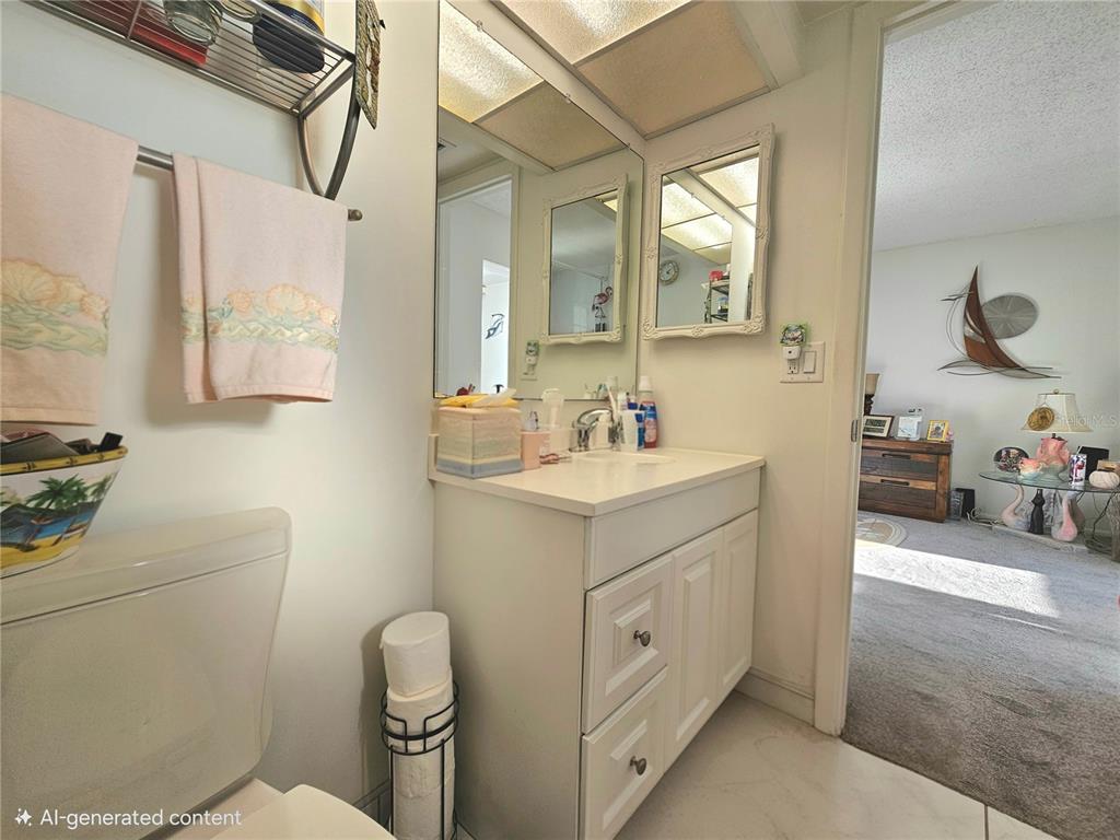 4525 Cove Circle, Unit 1002 St. Petersburg, FL 33708 - Photo 20 of 42 a bathroom with a toilet sink and mirror