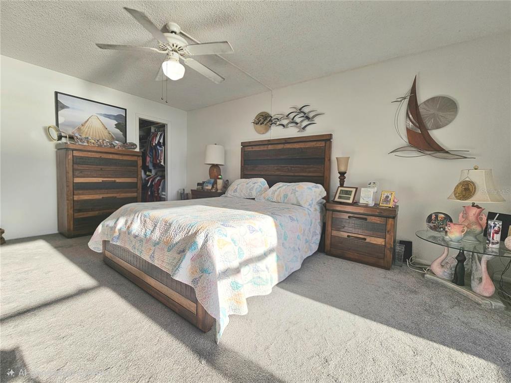 4525 Cove Circle, Unit 1002 St. Petersburg, FL 33708 - Photo 21 of 42 a bedroom with a bed and a chandelier