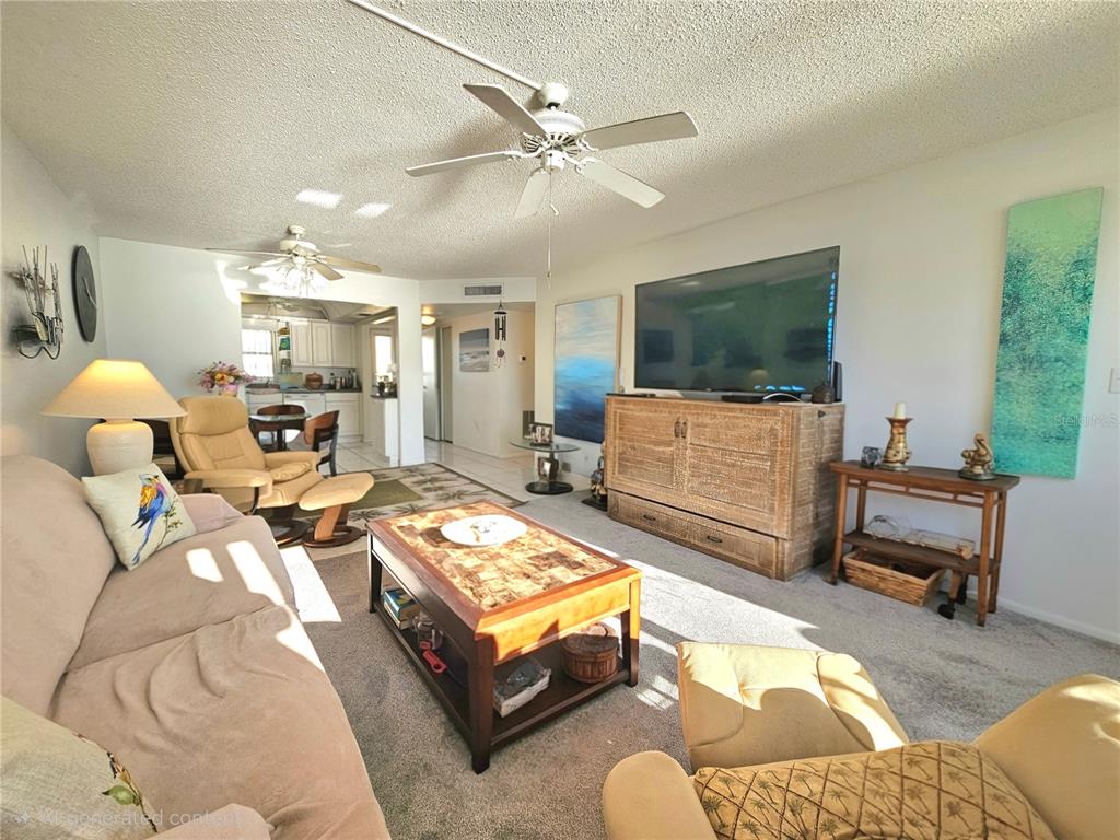 4525 Cove Circle, Unit 1002 St. Petersburg, FL 33708 - Photo 28 of 42 a living room with furniture and a flat screen tv
