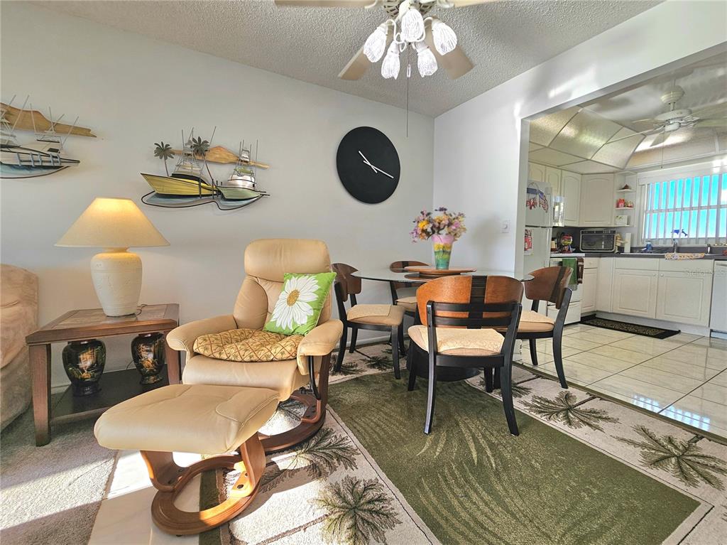 4525 Cove Circle, Unit 1002 St. Petersburg, FL 33708 - Photo 9 of 42 a dining room with furniture a chandelier and wooden floor