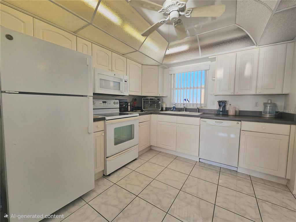 4525 Cove Circle, Unit 1002 St. Petersburg, FL 33708 - Photo 10 of 42 a kitchen with cabinets stainless steel appliances and a counter space
