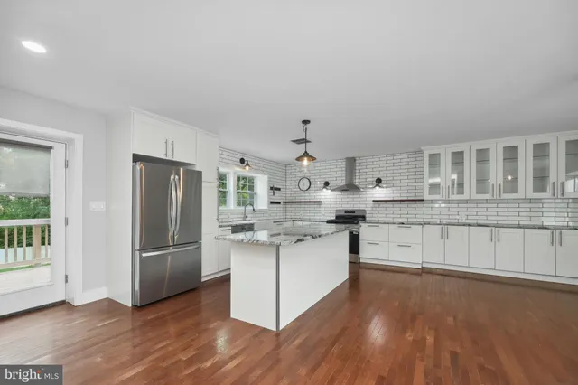 a kitchen with stainless steel appliances a sink cabinets and wooden floor