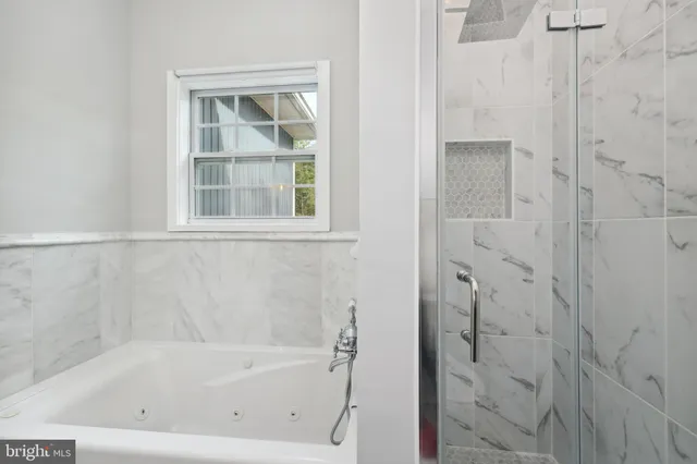 a white bath tub sitting next to a shower