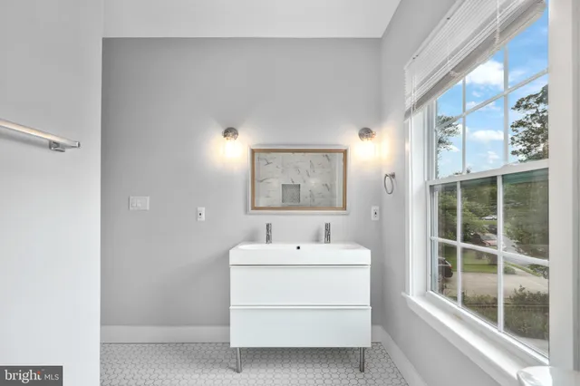 a bathroom with a sink mirror and a window