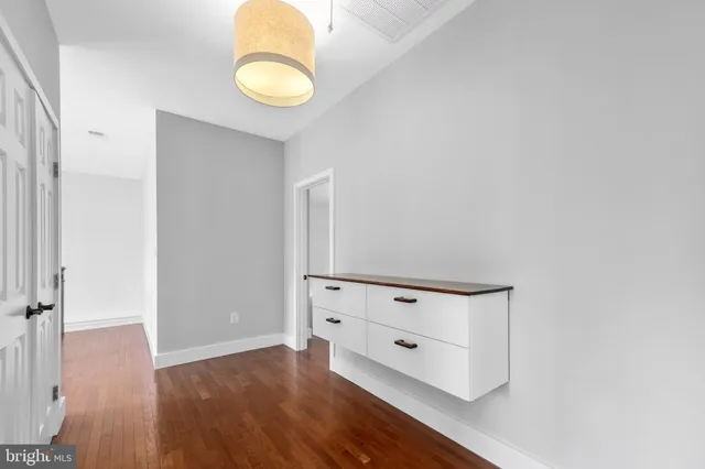 an empty room with wooden floor and cabinet