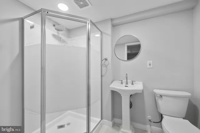 a bathroom with a sink mirror and toilet