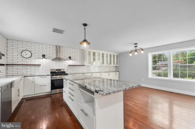 a open kitchen with granite countertop white cabinets and white appliances