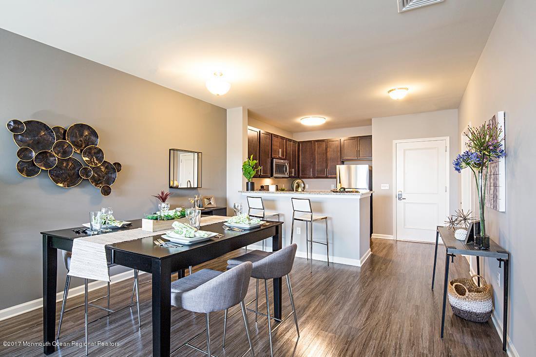 249 Broad Street, Unit 413 Matawan, NJ 07747 - Photo 18 of 27 a living room with kitchen island furniture and a wooden floor