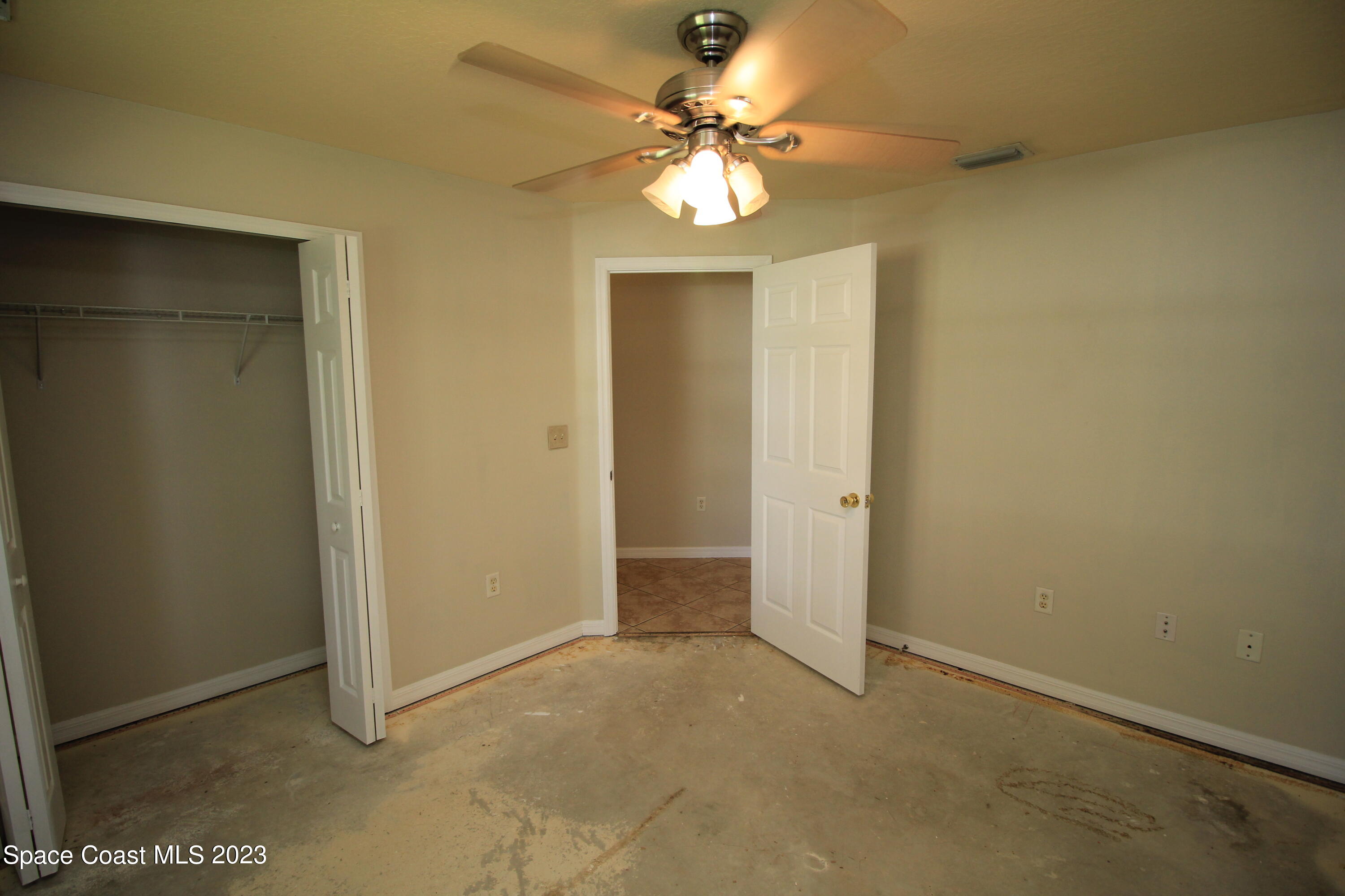 492 Eldron Boulevard Southeast Palm Bay, FL 32907 - Photo 19 of 28 an empty room with a chandelier fan and a window