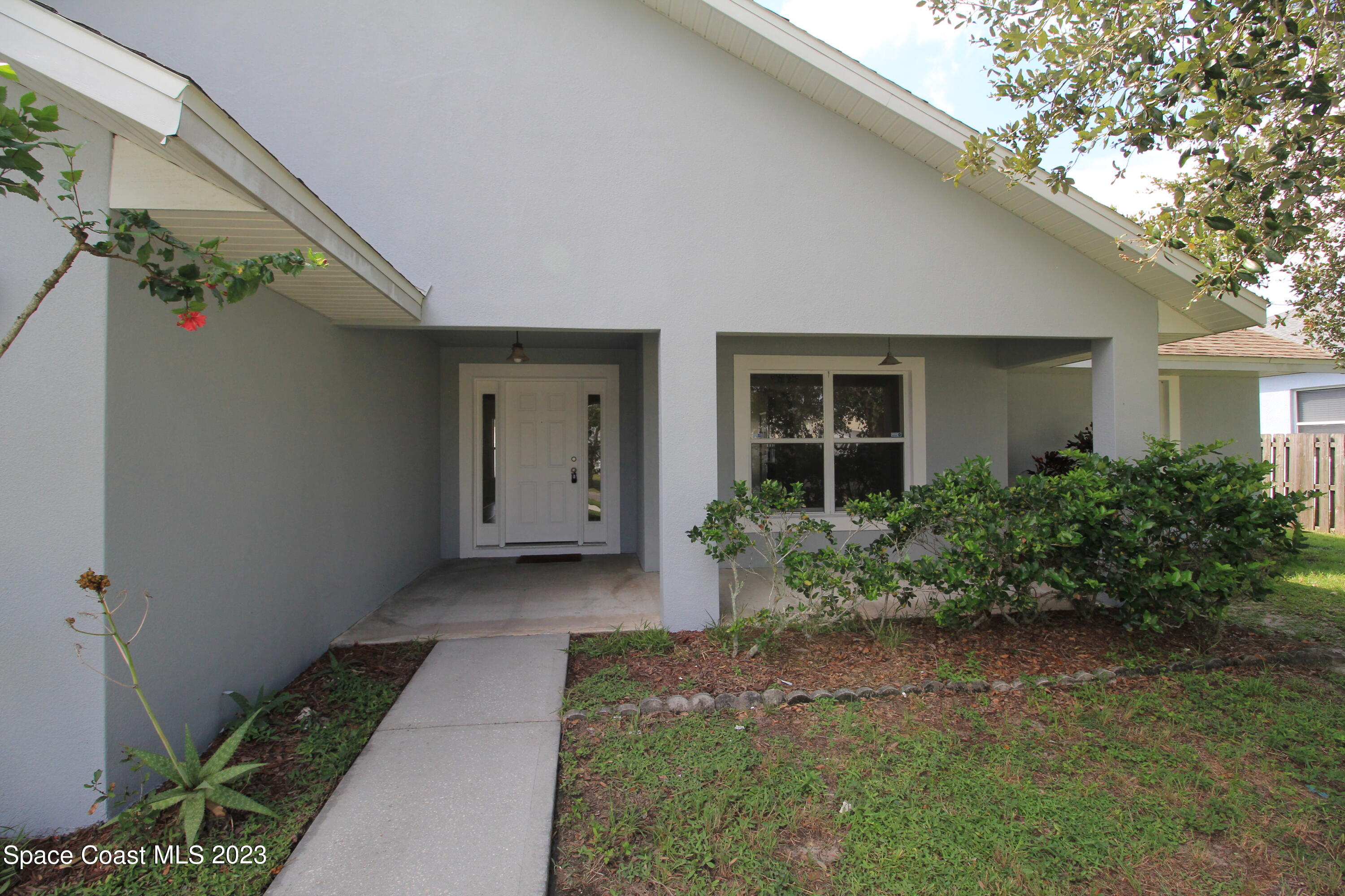 492 Eldron Boulevard Southeast Palm Bay, FL 32907 - Photo 2 of 28 a front view of a house with garden