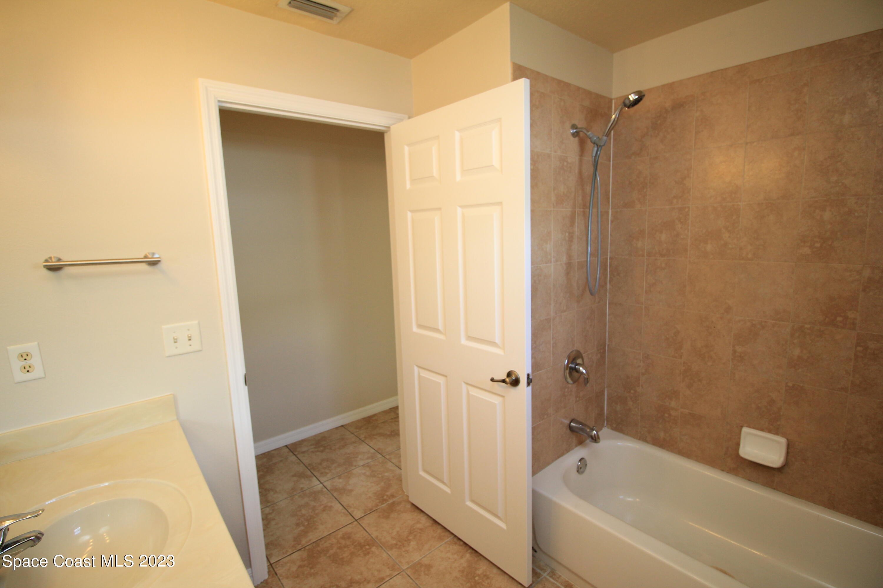 492 Eldron Boulevard Southeast Palm Bay, FL 32907 - Photo 21 of 28 a bathroom with a bathtub and a shower