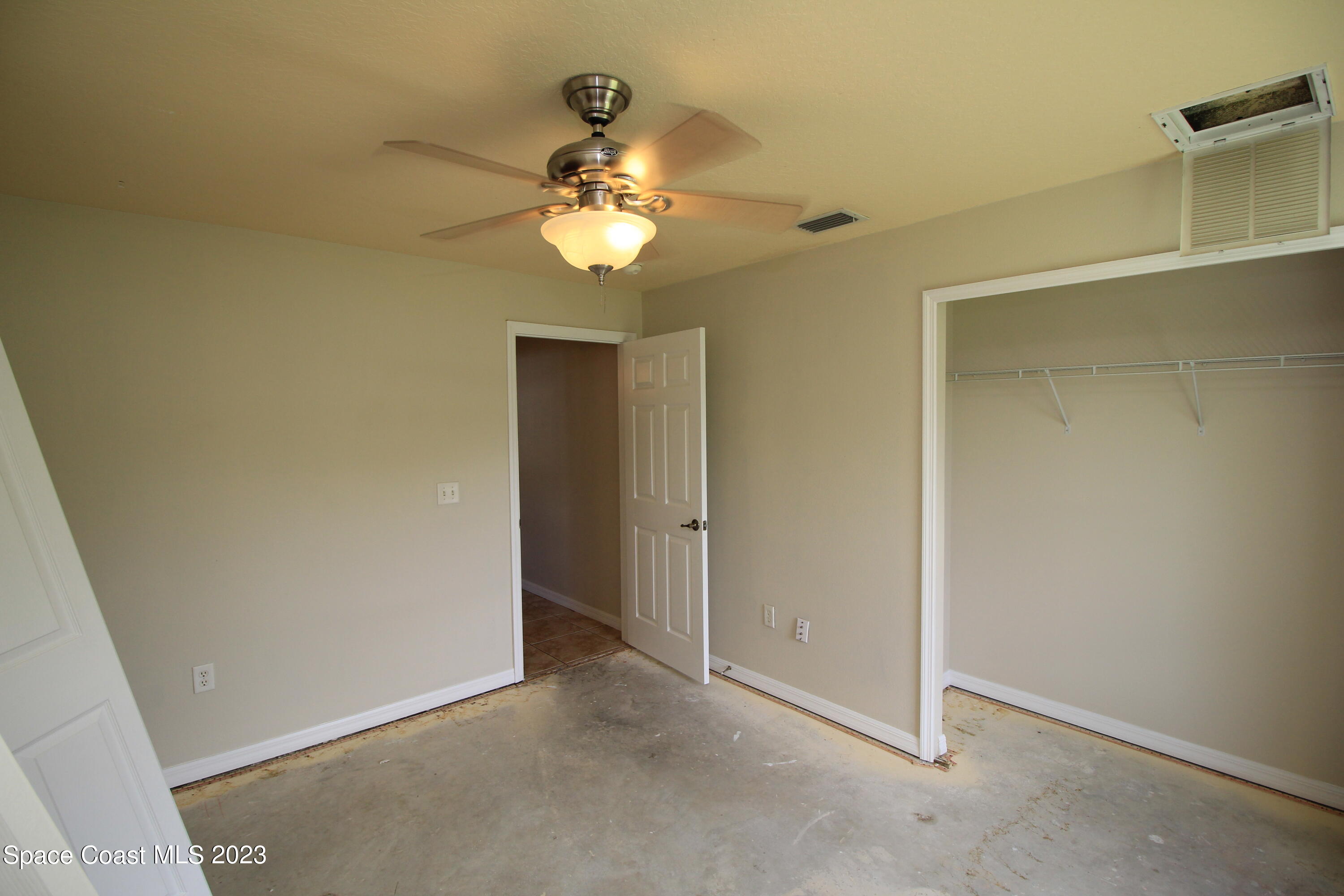 492 Eldron Boulevard Southeast Palm Bay, FL 32907 - Photo 23 of 28 an empty room with a mirror and a fan