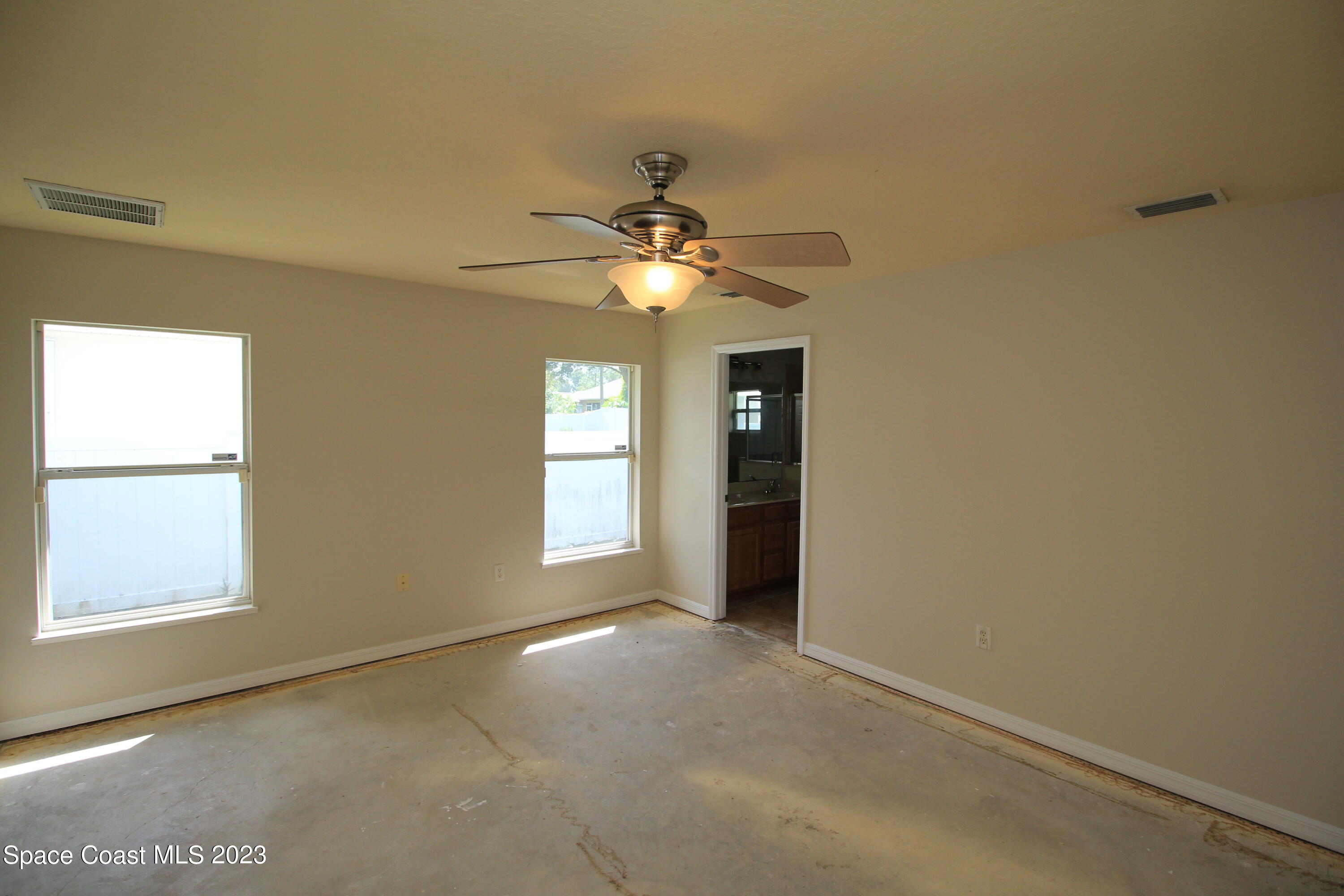 492 Eldron Boulevard Southeast Palm Bay, FL 32907 - Photo 25 of 28 an empty room with windows and ceiling fan