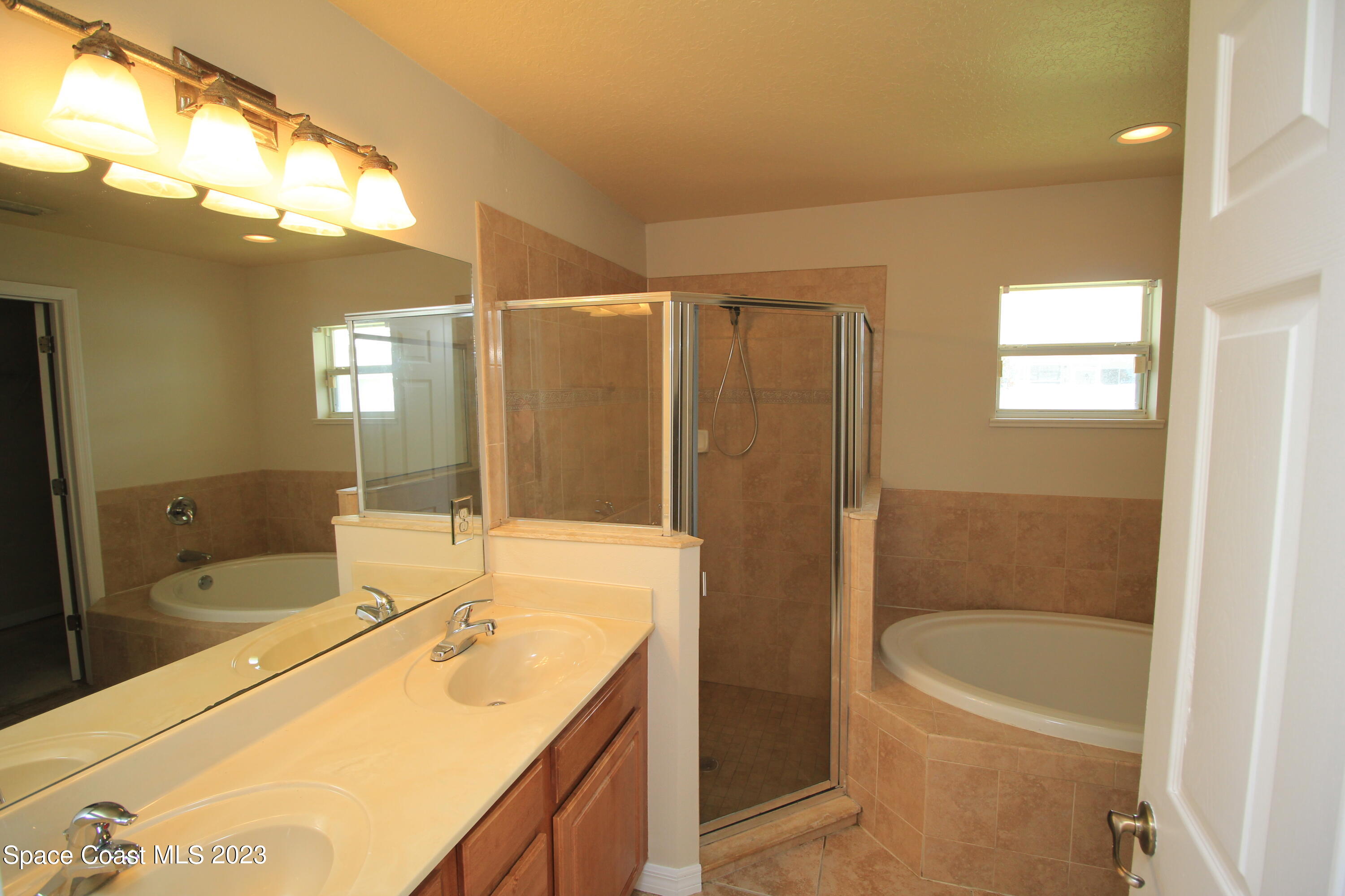 492 Eldron Boulevard Southeast Palm Bay, FL 32907 - Photo 27 of 28 a bathroom with a granite countertop sink a toilet a mirror and bathtub