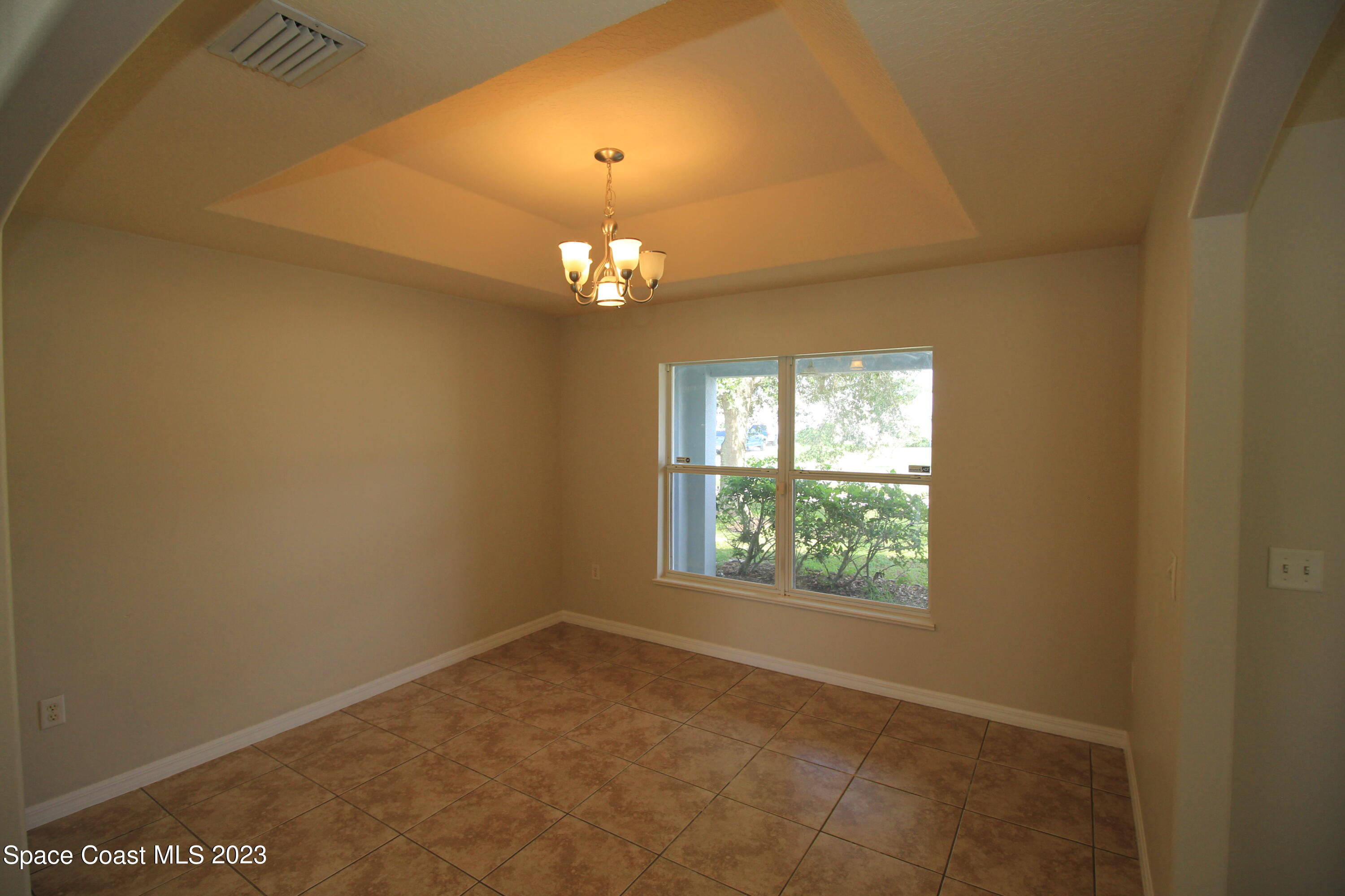 492 Eldron Boulevard Southeast Palm Bay, FL 32907 - Photo 8 of 28 an empty room with windows and chandelier