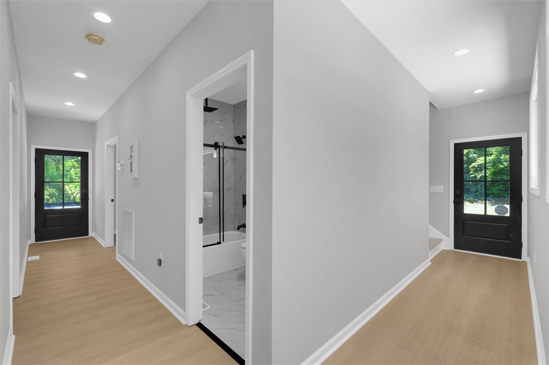 159 Cherokee Trail Easley, SC 29640 - Photo 6 of 38 A well-lit corridor welcomes you home, showcasing sleek wood flooring and recessed ceiling lights.