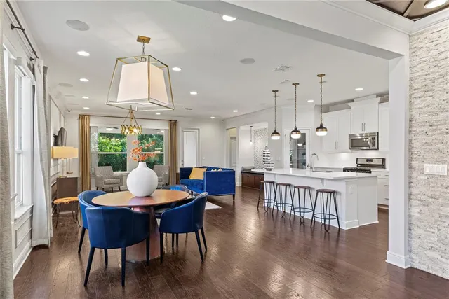 a dining room with furniture a chandelier and wooden floor