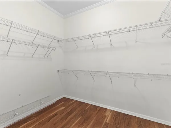 a view of a room with wooden floor and ceiling fan