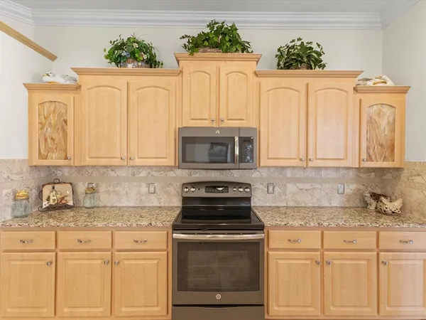 a kitchen with stainless steel appliances granite countertop a stove refrigerator sink and microwave