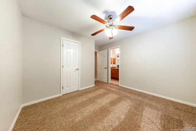 an empty room with closet and fan