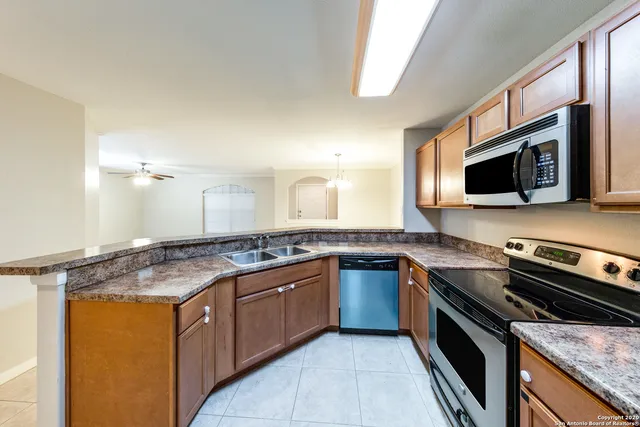 a kitchen with stainless steel appliances granite countertop stove top oven microwave and refrigerator