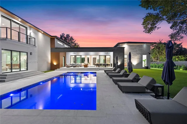 a view of a house with swimming pool and sitting area