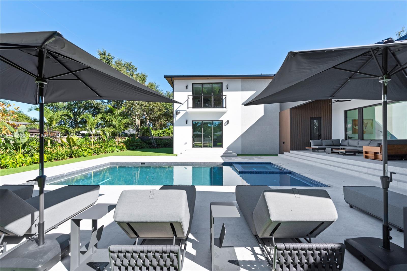 1881 Northeast 196th Terrace Miami, FL 33179 - Photo 39 of 98 a view of a patio with couches table and chairs under an umbrella
