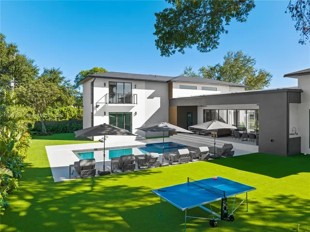 a view of a house with backyard and sitting area