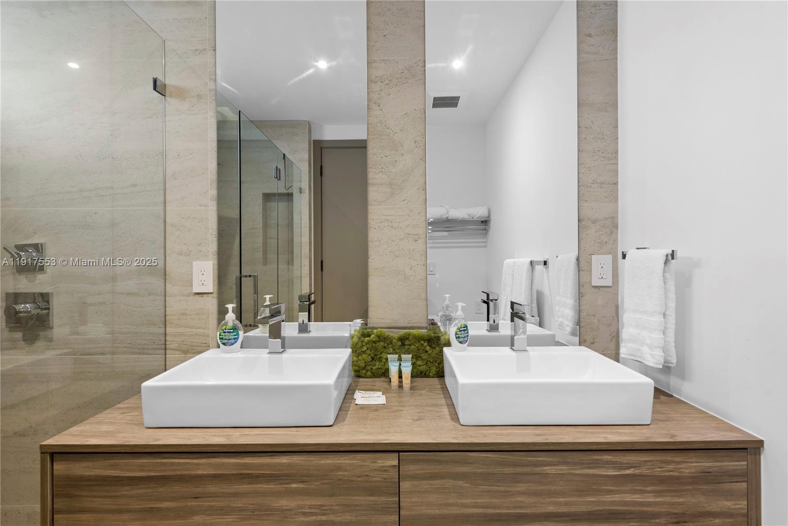 1881 Northeast 196th Terrace Miami, FL 33179 - Photo 66 of 98 a bathroom with double vanity and a mirror