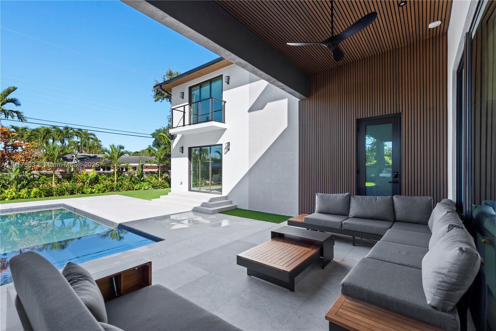 1881 Northeast 196th Terrace Miami, FL 33179 - Photo 8 of 98 a view of a patio with couches table and chairs with wooden floor and fence